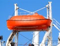 Red lifeboat on crane lift