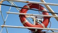 Red lifebuoy attached to a ship railing