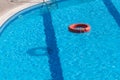 Red lifebuoy floating in hotel pool with beautiful blue water Royalty Free Stock Photo