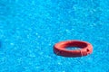 Red lifebuoy floating in hotel pool with beautiful blue water Royalty Free Stock Photo