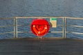 Red lifebuoy hanging on wooden pier, Jordan pond, Tabor, oldest dam in the Czech Republic, sunny autumn day, life insurance Royalty Free Stock Photo