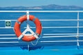 a red lifebuoy hangs on board a ferry cruise ship against the backdrop of a blue sea and a cloudless sky Royalty Free Stock Photo