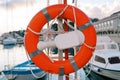 Red lifebuoy on a holder hanging from a pole on the pier Royalty Free Stock Photo