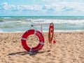 red lifebuoy with the inscription in Russian `Throw to a drowning man` on a beach against the background of a storm Royalty Free Stock Photo