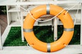 Orange Lifebuoy hanging on abstract cement wall Background Royalty Free Stock Photo