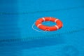 Red lifebuoy in the water in the pool. Lifebuoy on blue water surface Royalty Free Stock Photo