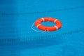 Red lifebuoy in the water in the pool. Lifebuoy on blue water surface Royalty Free Stock Photo