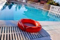 Red lifebuoy pool ring at swimming pool. Red pool ring in cool b Royalty Free Stock Photo