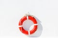 Red lifebuoy with white strip hanging on white wall , had space on left side for creative Royalty Free Stock Photo