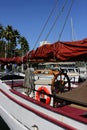 Red lifebuoy and wooden steering wheel on the deck of a sailing pleasure yacht moored in the tourist and recreational part of the Royalty Free Stock Photo