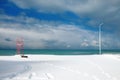 Red lifeguard tower construction and light pole on the beach covered with snow Royalty Free Stock Photo