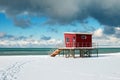 Red lifeguard tower construction on the snowy coast Royalty Free Stock Photo