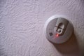 Red light batter indicator on a smoke detector mounted on a ceiling Royalty Free Stock Photo