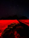 Red light on an empty brick and sandy path in the desert under the stars at night Royalty Free Stock Photo