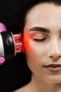 Red light of thermal or radio frequency on face of young woman for hardware RF lifting. Tightening and rejuvenation of Royalty Free Stock Photo