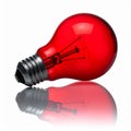 Red Lightbulb on Glossy Surface Reflecting Light against White Background Royalty Free Stock Photo