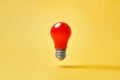 Red lightbulb levitate on yellow background. Idea, motivation concept