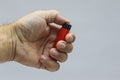 A red lighter in his hand close-up on a light background. Royalty Free Stock Photo