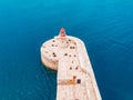 Red lighthouse alone against blue water of sea. Aerial top view Royalty Free Stock Photo