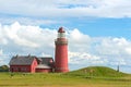 The red Lighthouse Bovbjerg Fyr with green grass and blue sky, J