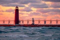 a red lighthouse that has some lights on it at sunset Royalty Free Stock Photo