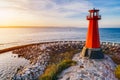 Red lighthouse on the rocky seashore Royalty Free Stock Photo