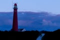 the red lighthouse of Schiermonnikoog during the blue hour in the evening in the province of Friesland, the Netherlands Royalty Free Stock Photo