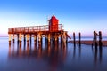 Red lighthouse on the sea in Lignano Sabbiadoro. Punta Faro Beach.