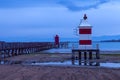 Red lighthouse on the sea in Lignano Sabbiadoro. Punta Faro Beach.