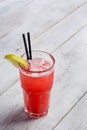 Red limonade in glass on white wooden background