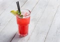 Red limonade in glass on white wooden background. With space for your text.