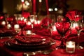 Red linens, elegant dinnerware, and romantic candlelight