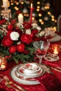 Red linens, elegant dinnerware, and romantic candlelight