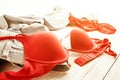 Red lingerie and jeans scattered on the floor. Messy clothes