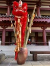 A red lion dance head custom and firecrakers placed on a Long bamboo for decoration.