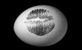 Red lip imprint on easter egg on black background. Print of red lips on white egg. Egg hunt. Royalty Free Stock Photo