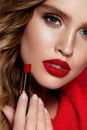 Red Lips. Beautiful Woman With Beauty Makeup Holding Lipstick.