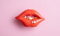 Red lips full of tablets and pills on pink background. Creative medical poster. Health care concept Royalty Free Stock Photo