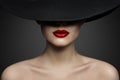 Red Lips Make up Closeup. Mysterious Fashion Woman Face Hidden by Black brimmed Hat. Elegant Retro Lady Fine Art Portrait