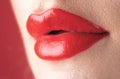 Red lipstick. Glossy make-up for plump natural lips. Lipstick and pomade. Close up red lips. Pink lipstick. Pomade