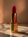 Red lipstick in gold packaging on a marbled surface. Royalty Free Stock Photo