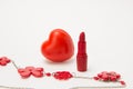 Red lipstick, heart and necklace with flowers on a white background Royalty Free Stock Photo