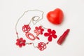 Red lipstick, heart and necklace with flowers on a white background Royalty Free Stock Photo