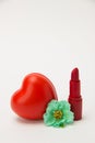 Red lipstick, heart and necklace with flowers on a white background Royalty Free Stock Photo