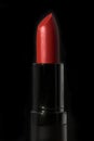 Red lipstick isolated on black background