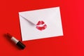 Red lipstick kiss on white envelope on red background. Royalty Free Stock Photo