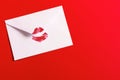 Red lipstick kiss on white envelope on red background. Royalty Free Stock Photo