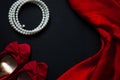 Red shoes, pearl necklace, silk handkerchief on a black background Royalty Free Stock Photo