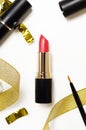 Red lipstick and lip brush top view composition. Makeup accessories and golden decorations on white background. Beauty industry