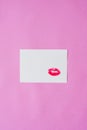 Red lipstick lip print Kiss on white paper sheet on red